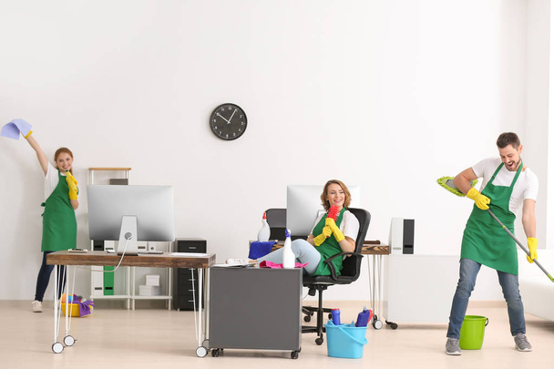 Team of young cleaning service professionals at work in office - Φωτογραφία, εικόνα