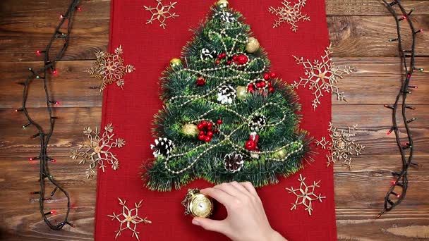 uma pequena árvore de Natal de ouropel, nozes, fitas e ornamentos. Presente para uma árvore de Natal, um relógio vintage. 2018
, - Filmagem, Vídeo