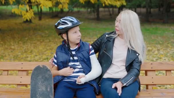 Mutter und Sohn sitzen auf Bank im Park - Filmmaterial, Video