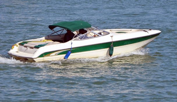 Barco a motor con dosel verde oscuro que navega lentamente por la vía fluvial costera de Florida frente a Miami Beach
. - Foto, imagen