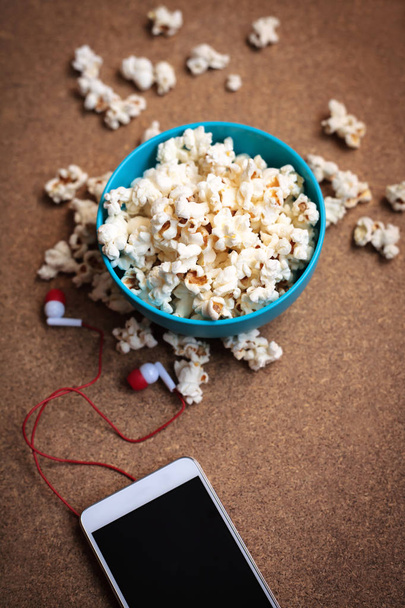 popcorn on a table with a smartphone - Фото, изображение