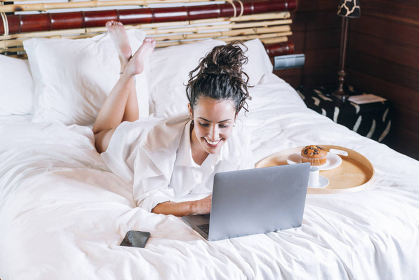 Ładna kobieta z telefonu i laptopa w łóżku - Zdjęcie, obraz