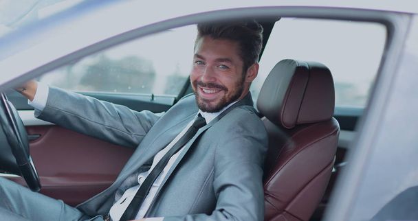 Portrait of an handsome smiling business man driving his car - Foto, imagen
