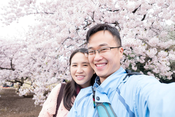 couple selfie happily with Cherry blossoms in the park - Foto, immagini