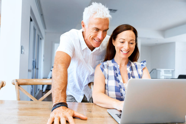 Szczęśliwy nowoczesne Starsza para działa na laptopie w domu - Zdjęcie, obraz