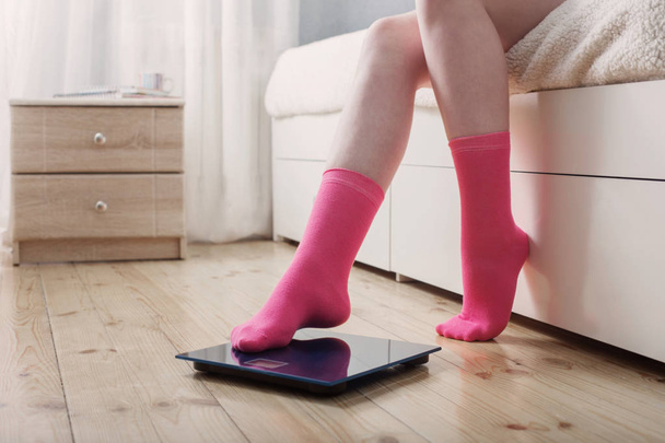 female feet in socks on the floor scales - Foto, Imagen
