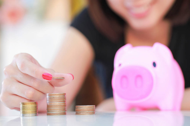 Female hand putting money into piggy bank. - Foto, Imagem