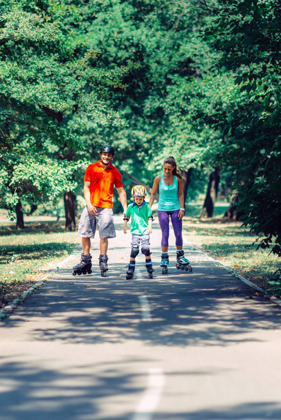 Rodina s dítě na kolečkových bruslích v parku - Fotografie, Obrázek