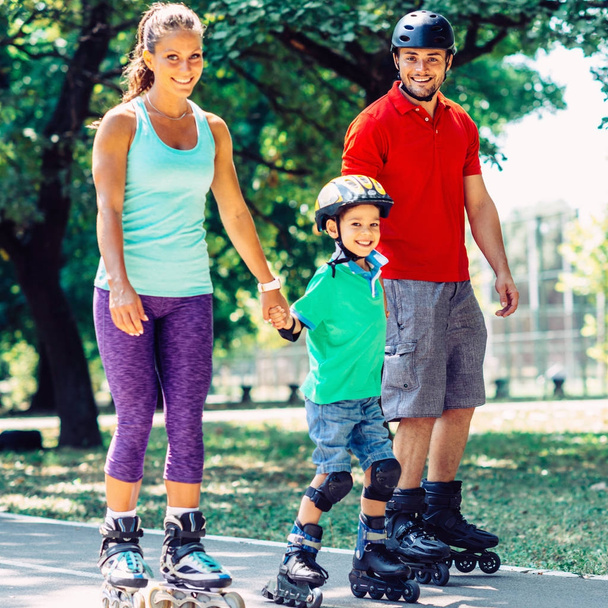 Retrato de familia sobre patines en parque
 - Foto, Imagen