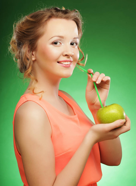 smiling woman with apple and Straws Cocktail, over green backgro - Fotografie, Obrázek