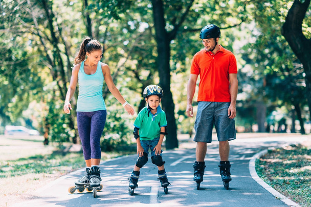 Familia alegre patinaje sobre ruedas en el parque
 - Foto, imagen