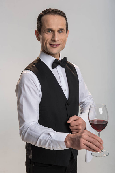 Attractive male waiter proposing wine - Fotó, kép