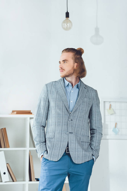 handsome businessman standing in office and looking away - Фото, зображення