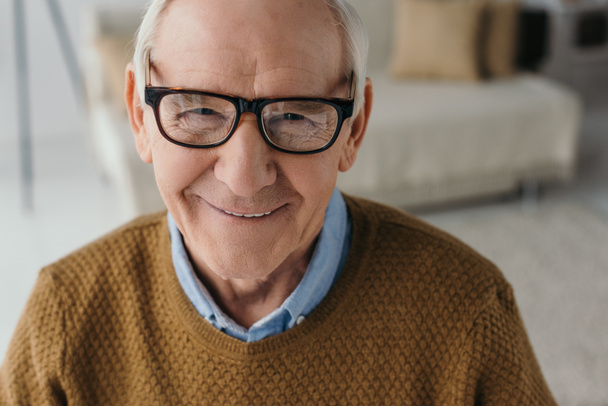 Старший улыбающийся мужчина в очках и смотрит в камеру
 - Фото, изображение