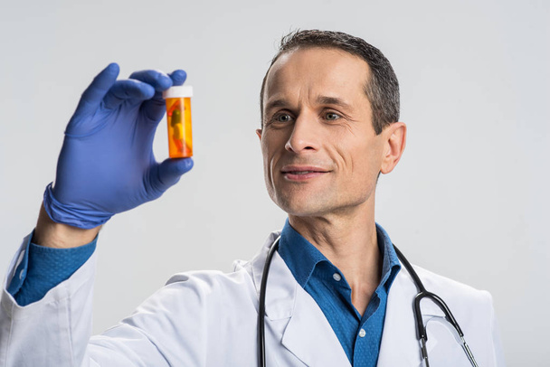 Glad male doctor studying medication - Фото, зображення