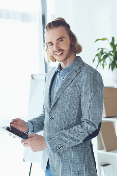 smiling businessman standing with tablet and looking at camera - Foto, Imagem