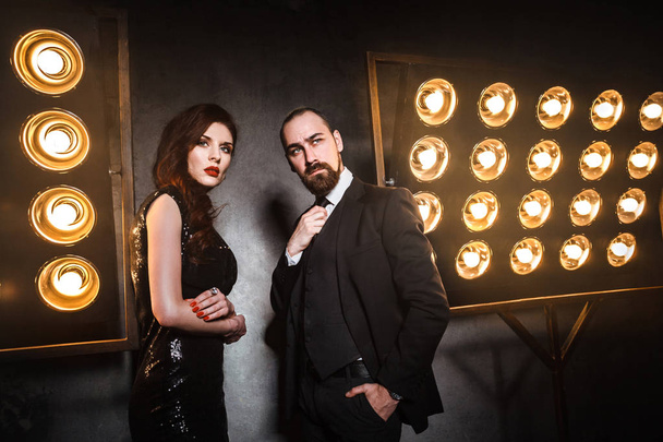 well dressed couple posing near stage with lamps, luxury and richly concept - Photo, image