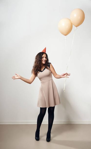 happy young woman or teen girl in brown dress with helium air balloons - Photo, Image