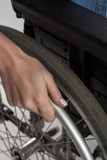 Close up of female hand put on the wheelchair wheel - Φωτογραφία, εικόνα