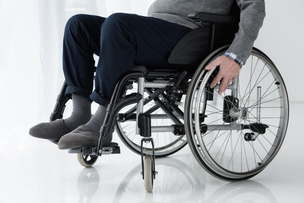 Close-up view of senior man hand on wheel of wheelchair - Fotoğraf, Görsel