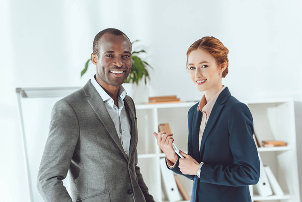 smiling african american businessman and caucasian businesswoman looking at camera - Photo, Image
