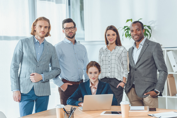 business team standing against sitting woman at office space   - Fotoğraf, Görsel