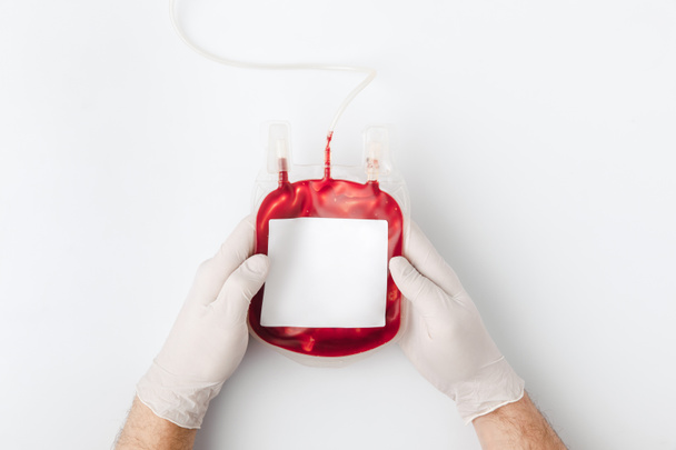 vista superior de las manos en guantes con sangre para transfusión aislada sobre fondo blanco
    - Foto, imagen