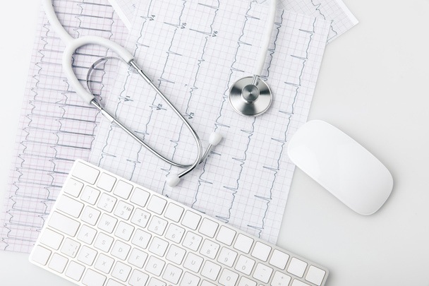 stetoskop, klávesnice a počítač myš položení na papíře s kardiogram izolovaných na bílém pozadí      - Fotografie, Obrázek
