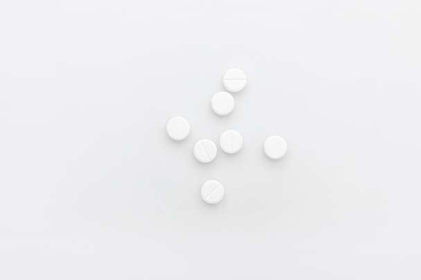 verspreide witte pillen geïsoleerd op witte achtergrond    - Foto, afbeelding