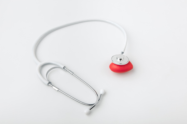 estetoscópio com coração vermelho deitado isolado sobre fundo branco
     - Foto, Imagem