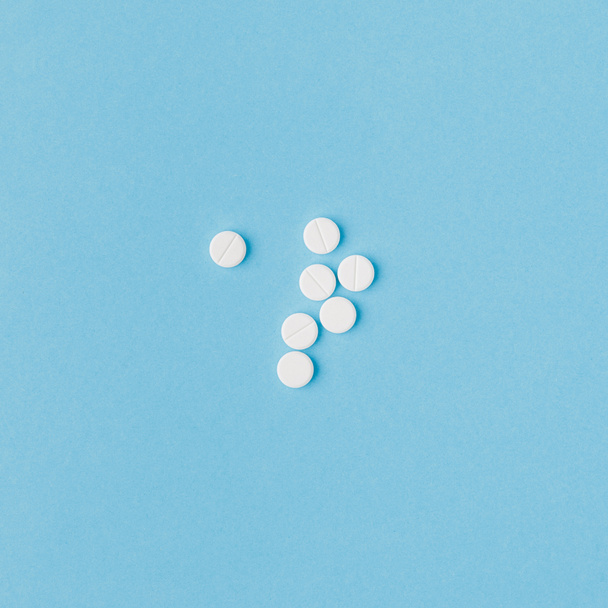 scattered white pills isolated on blue background  - Fotó, kép