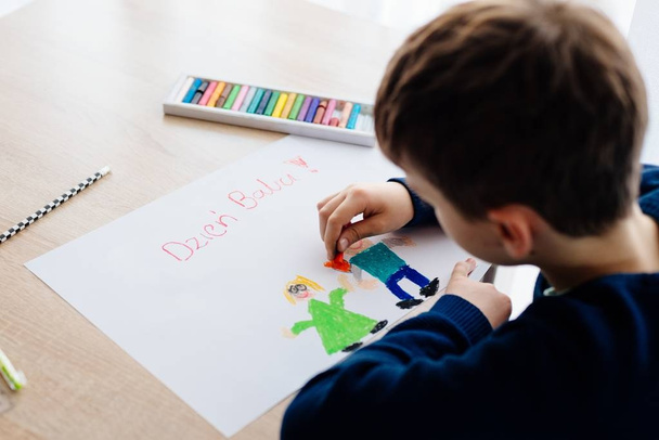 Criança polonesa feliz desenhando um cartão de saudação para sua avó
. - Foto, Imagem