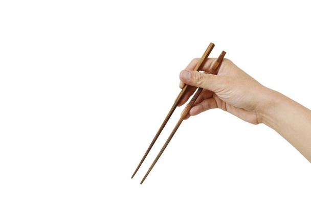 рука тримає і використовує дерев'яні палички на білому тлі
 - Фото, зображення