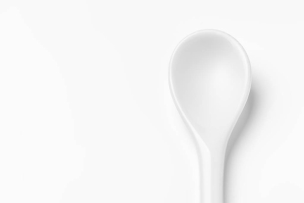 Cucchiaio bianco isolato su una superficie bianca
 - Foto, immagini