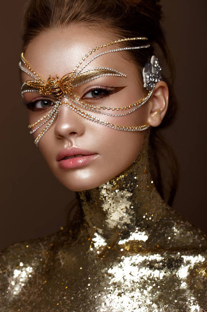 Beautiful girl in golden mask and bright evening make-up. Beauty face. - Φωτογραφία, εικόνα