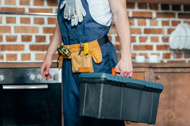 cropped shot of home master with tool belt holding toolbox - Photo, Image