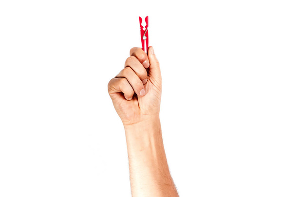 ένας άνθρωπος του χέρι κρατά ένα clothespin σε λευκό φόντο, απομόνωση. - Φωτογραφία, εικόνα