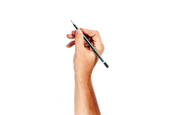 A man's hand holds a black pencil on a white background, isolate. - Zdjęcie, obraz