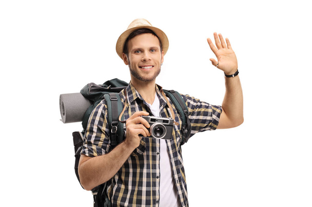 Turista con cámara y mochila saludando
 - Foto, Imagen