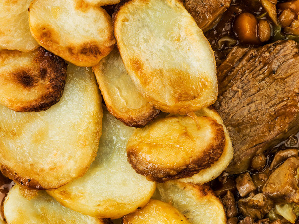 Lammas Hotpot viipaloitu perunat ja sipulikastiketta
 - Valokuva, kuva