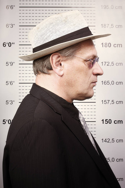 Oudere criminele man schilderde in zonnebril en hoed voor mok bestuur - Foto, afbeelding