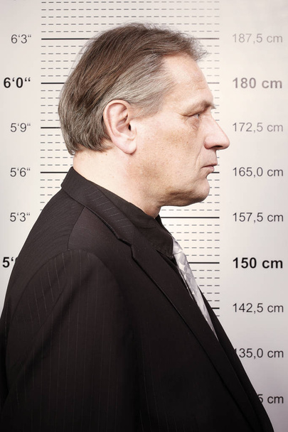 Malo hombre criminal retratado en la estación de policía en frente de la junta de la taza
 - Foto, imagen
