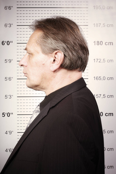 Homme criminel plus âgé représenté sur le poste de police devant le tableau de bord
 - Photo, image