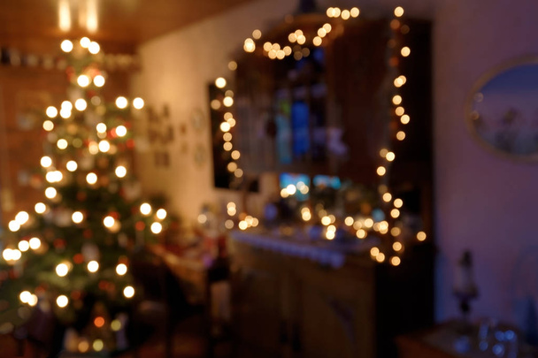 Bokeh παρασκηνίου - ατμοσφαιρικά φωτισμένη οικογενειακό δωμάτιο στο χρόνο Χριστουγέννων - Φωτογραφία, εικόνα