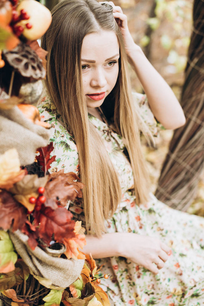 young beautiful blonde woman posing in autumn decorations - 写真・画像