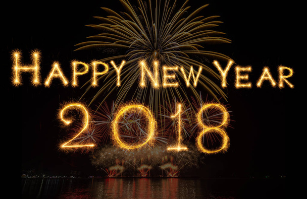 Szczęśliwego nowego roku 2018 napisane w blasku fajerwerków na fajerwerki z ciemnego tła, celebracja i kartki z życzeniami koncepcja - Zdjęcie, obraz