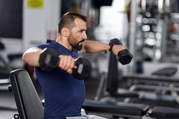 Man doing shoulder workout with dumbbells - Zdjęcie, obraz