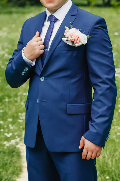 A man buttoning a blue jacket - Фото, изображение