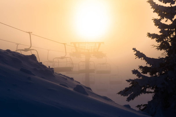 Sandalye teleferik ile kayakçı sillhouettes gün batımında - Fotoğraf, Görsel