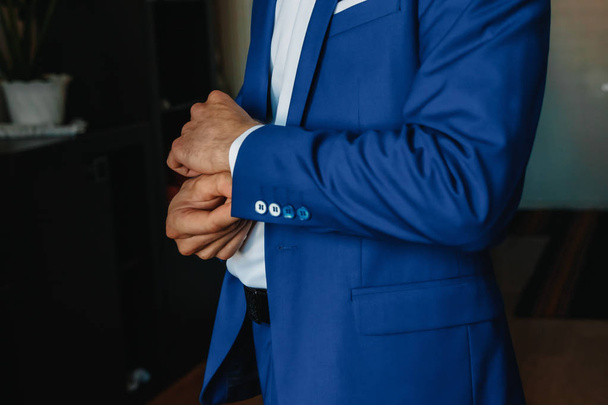 A man buttoning a blue jacket - Foto, afbeelding